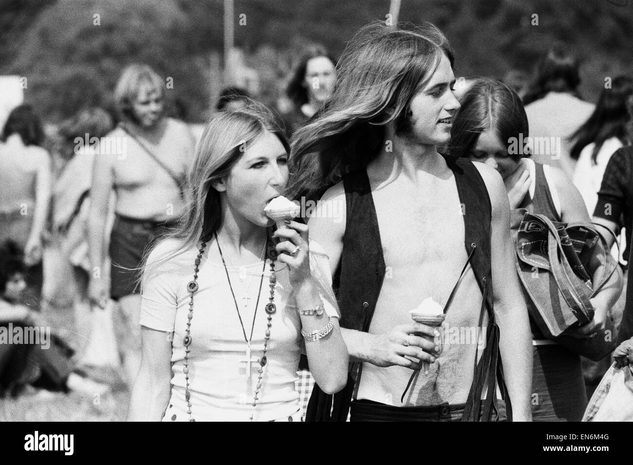 Lecture de musique pop. Festivaliers manger des glaces comme ils font leur chemin vers la scène principale pour voir le les bandes. 24 août 1973. Banque D'Images