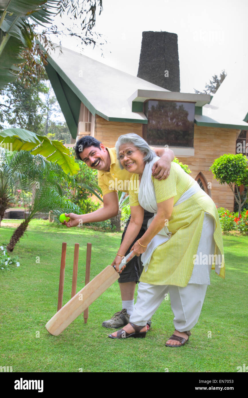 Senior woman jouer au cricket avec son fils Banque D'Images