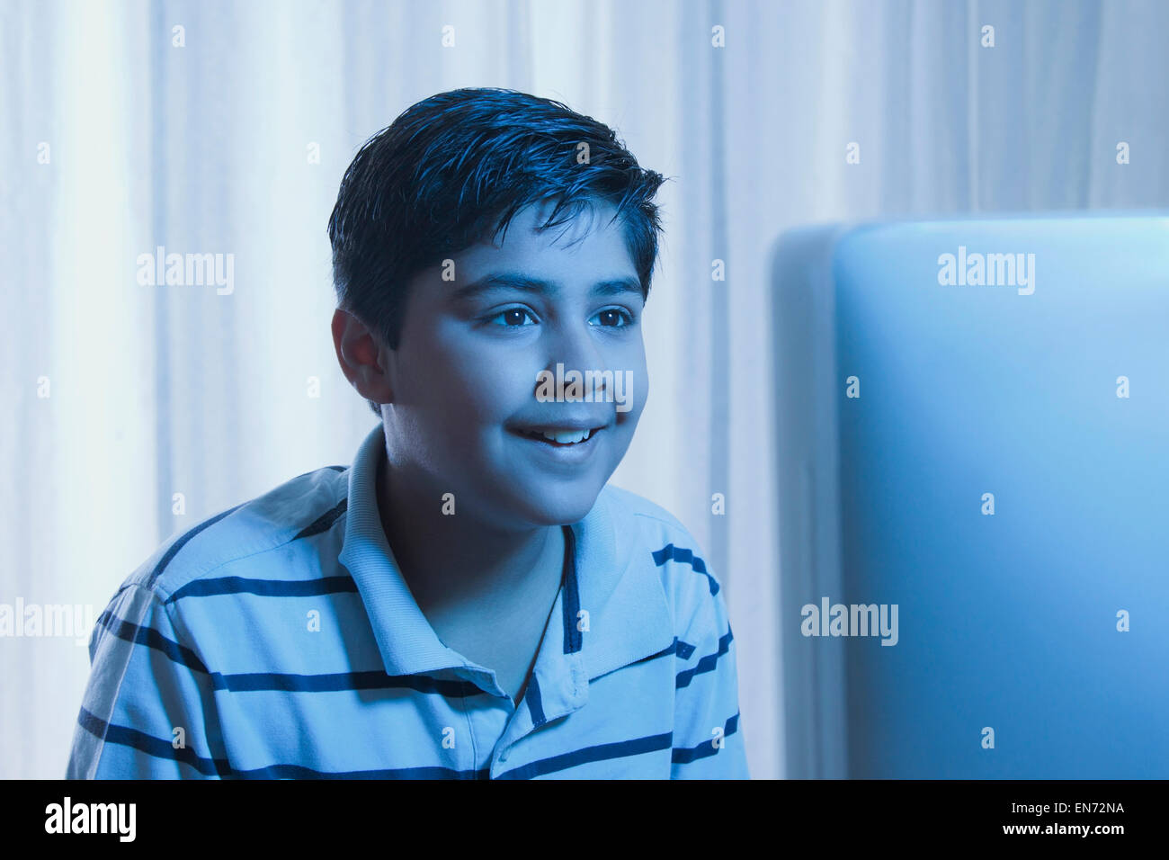 Jeune garçon à la recherche à l'écran d'un ordinateur Banque D'Images