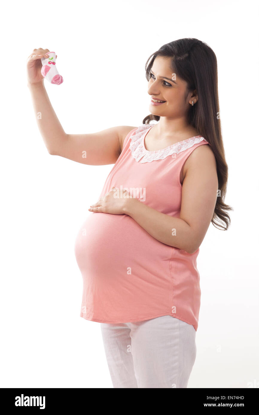 Pregnant woman holding baby shoes Banque D'Images