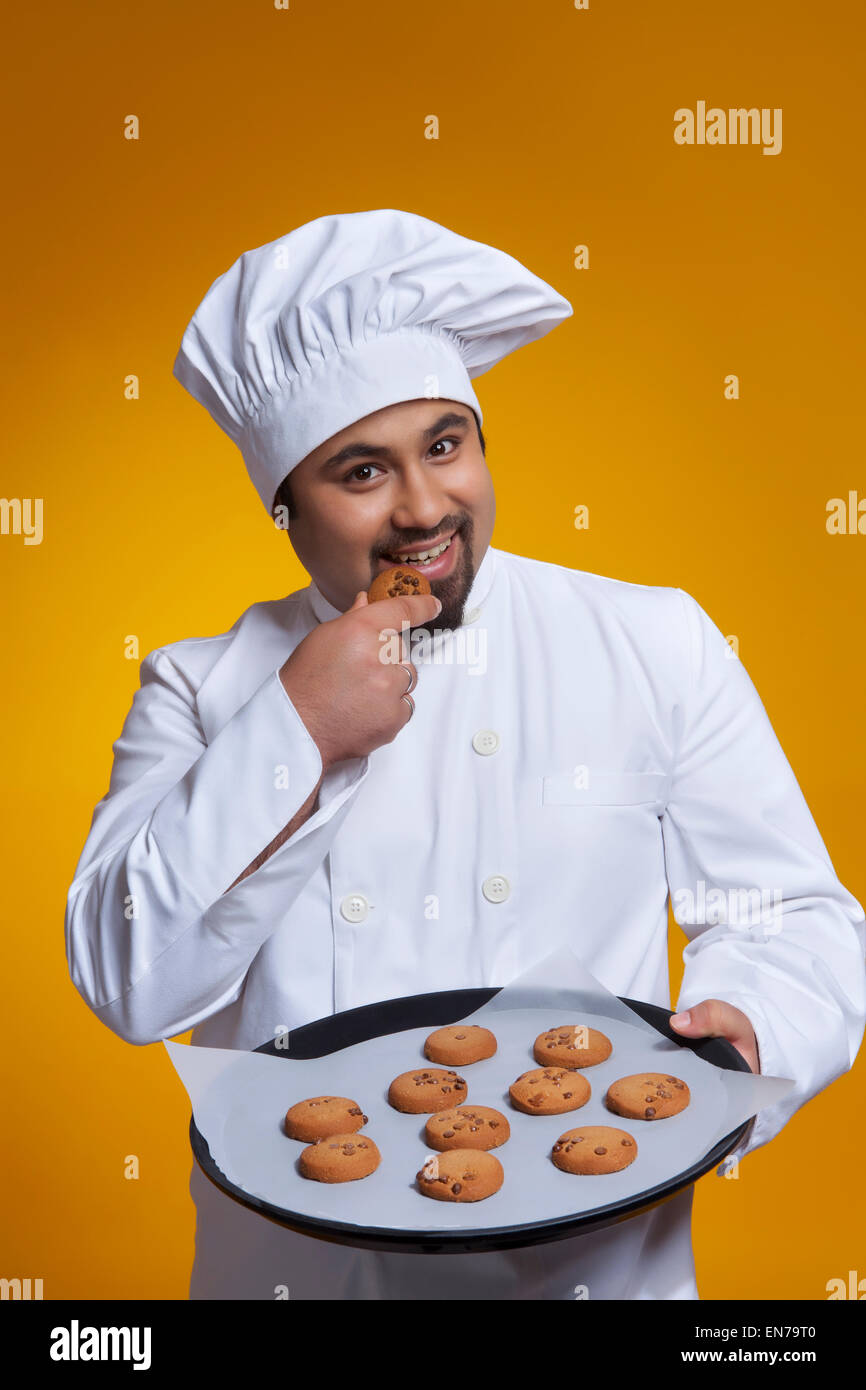 Portrait of chef de manger un cookie Banque D'Images