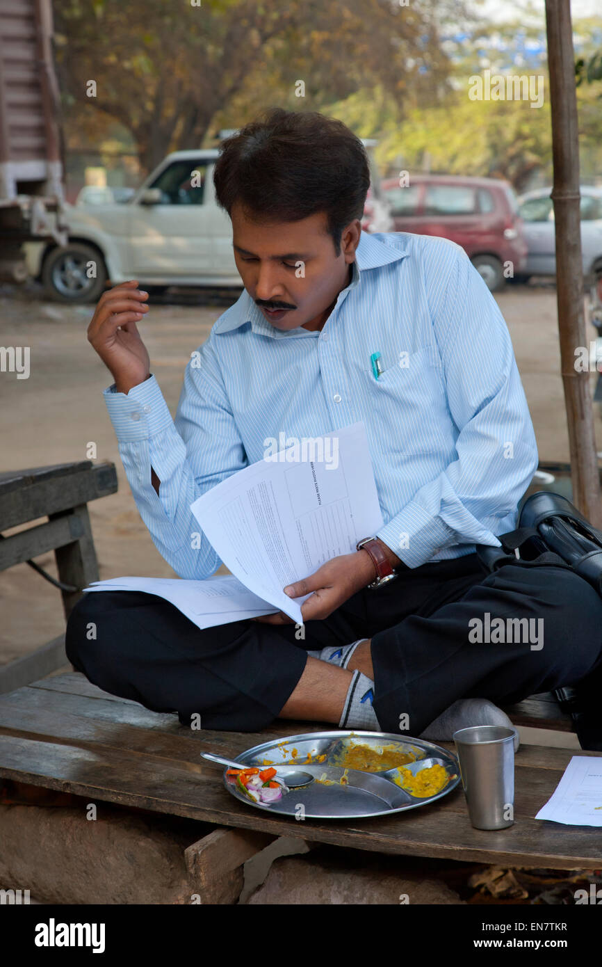 Vendeur en train de déjeuner et à la recherche de travail en papier Banque D'Images