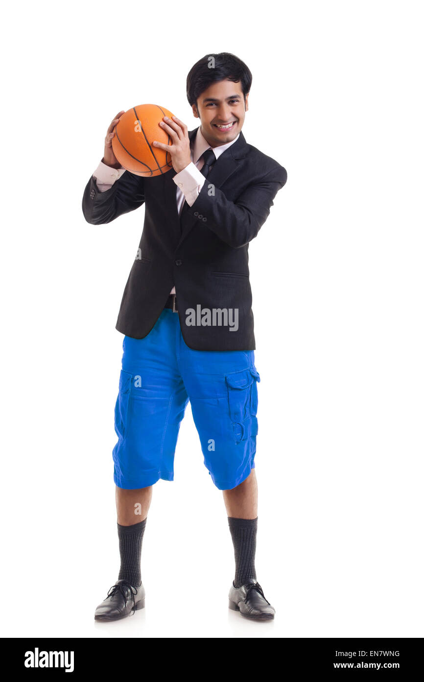 Portrait of smiling young man holding basketball Banque D'Images