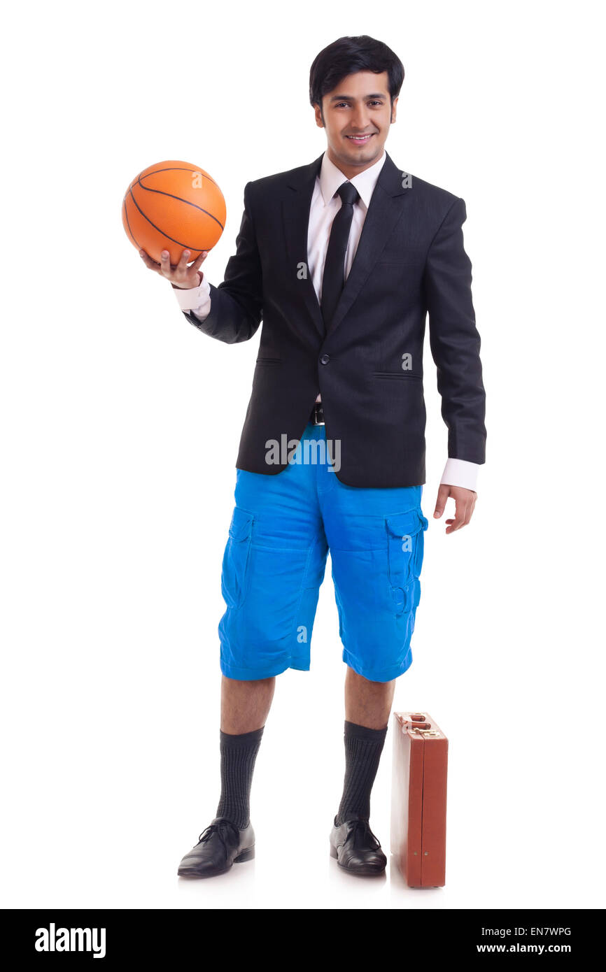 Portrait of smiling young man holding basketball Banque D'Images