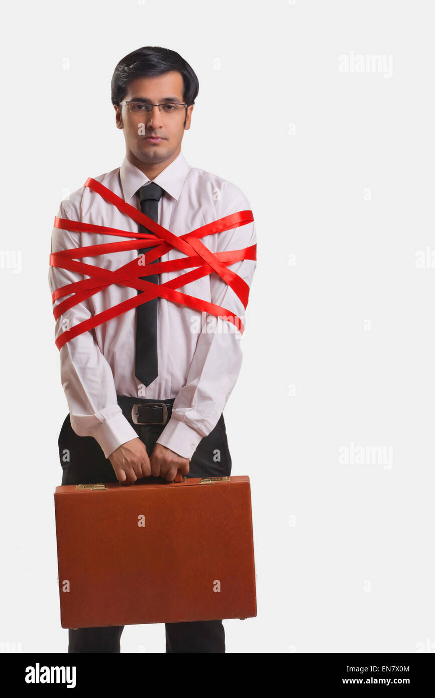 Businessman tied up with red ribbon Banque D'Images