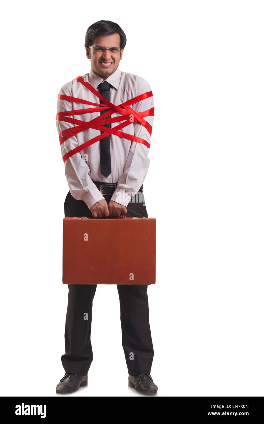 Businessman tied up with red ribbon Banque D'Images