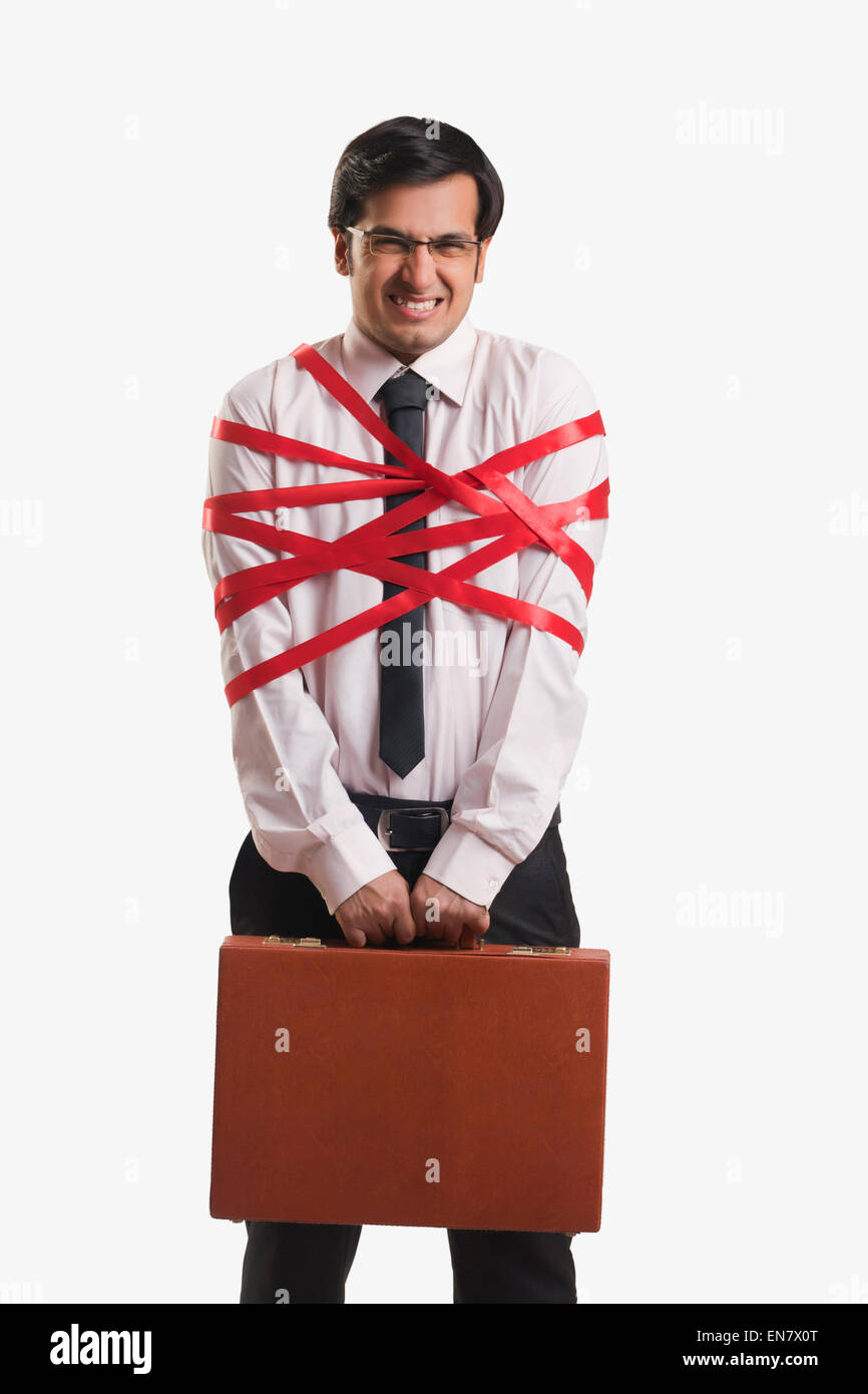 Businessman tied up with red ribbon Banque D'Images