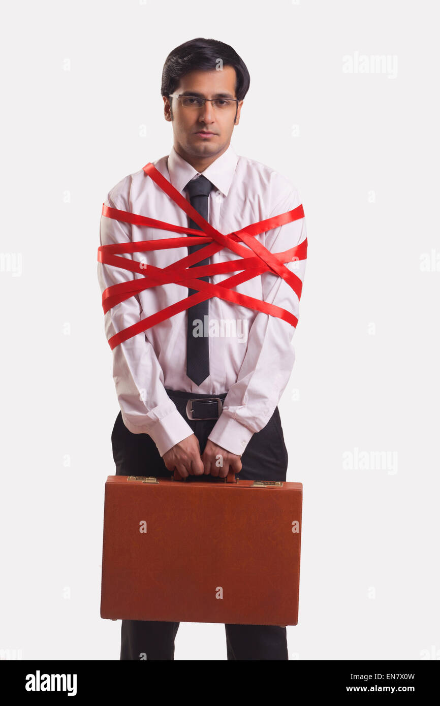 Businessman tied up with red ribbon Banque D'Images