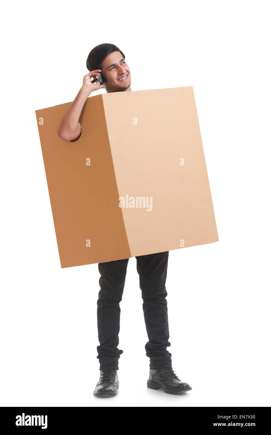 A smiling man in a box listening to music on headphones Banque D'Images