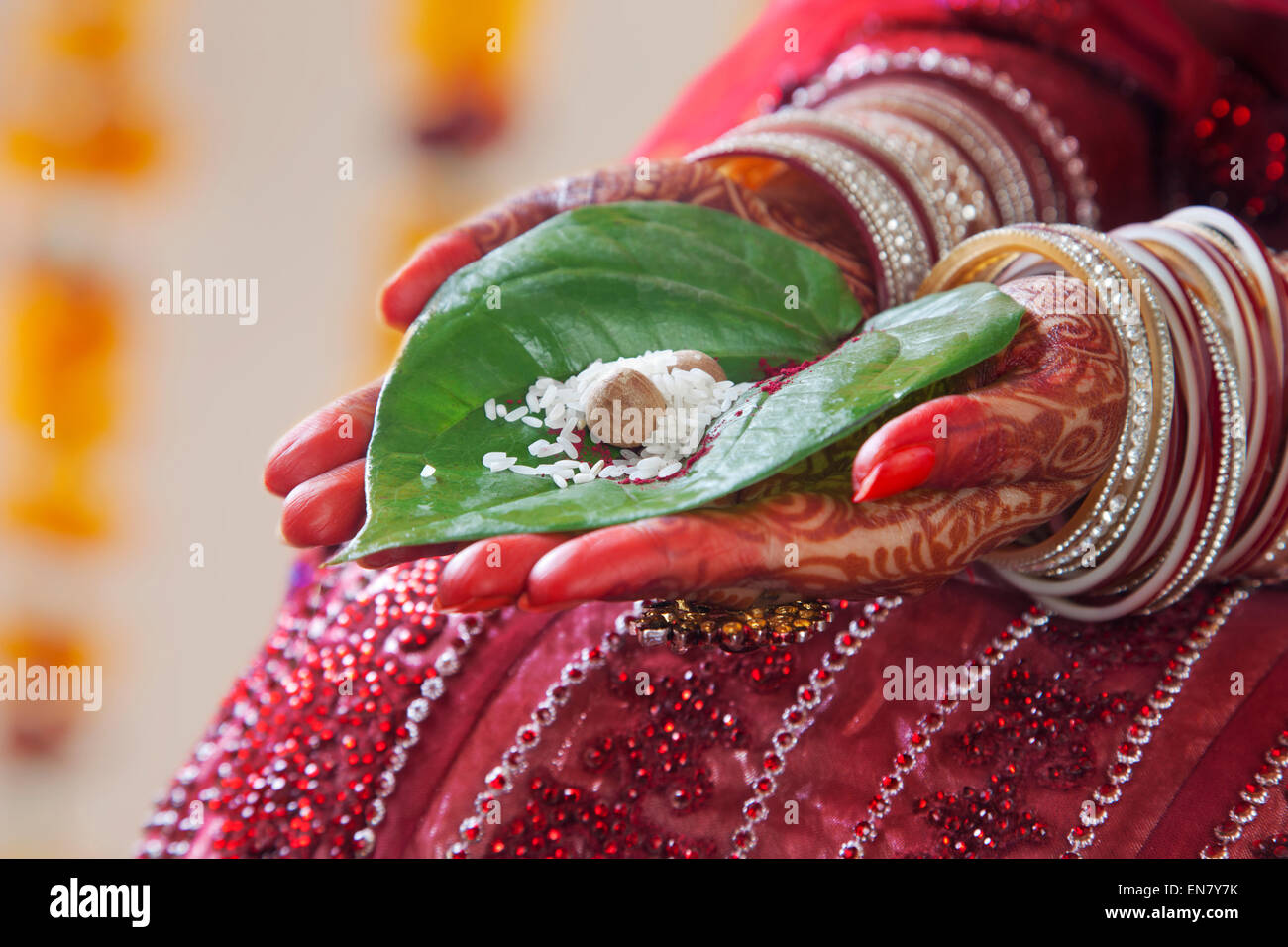 Close-up of a Brides mains effectuant des rituels de mariage avec des feuilles de riz et paan Banque D'Images