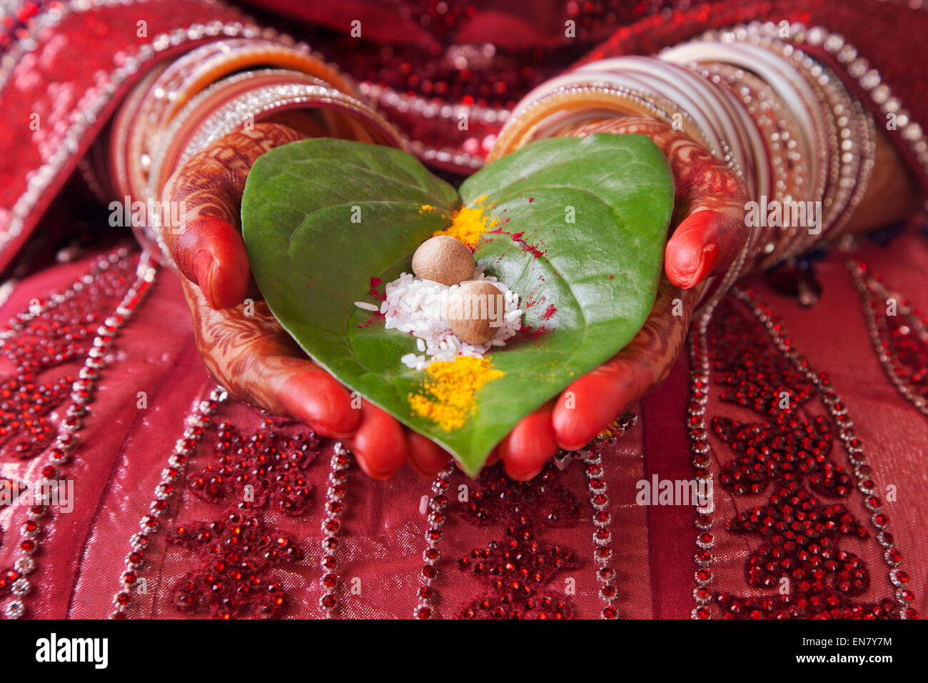 Close-up of a Brides mains effectuant des rituels de mariage avec des feuilles de riz et paan Banque D'Images