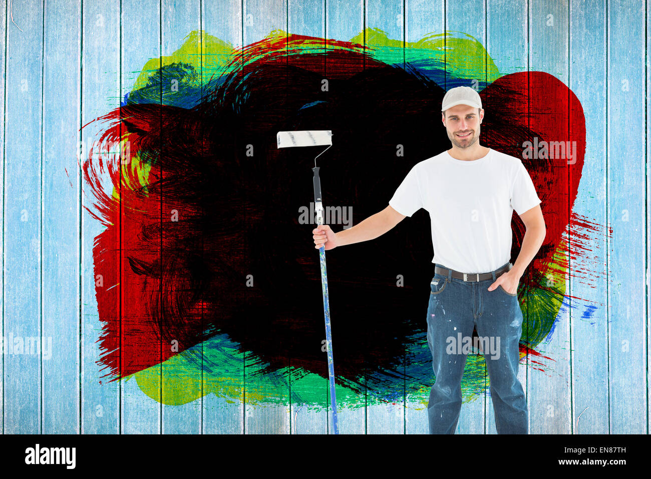 Image composite de l'homme confiant holding paint roller sur fond blanc Banque D'Images