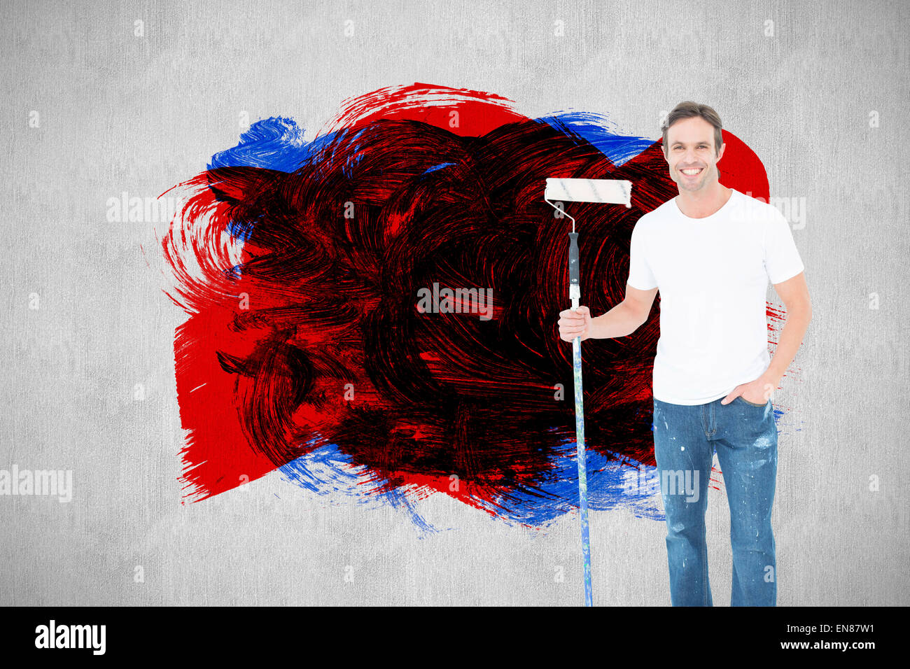 Image composite de l'homme confiant holding paint roller sur fond blanc Banque D'Images