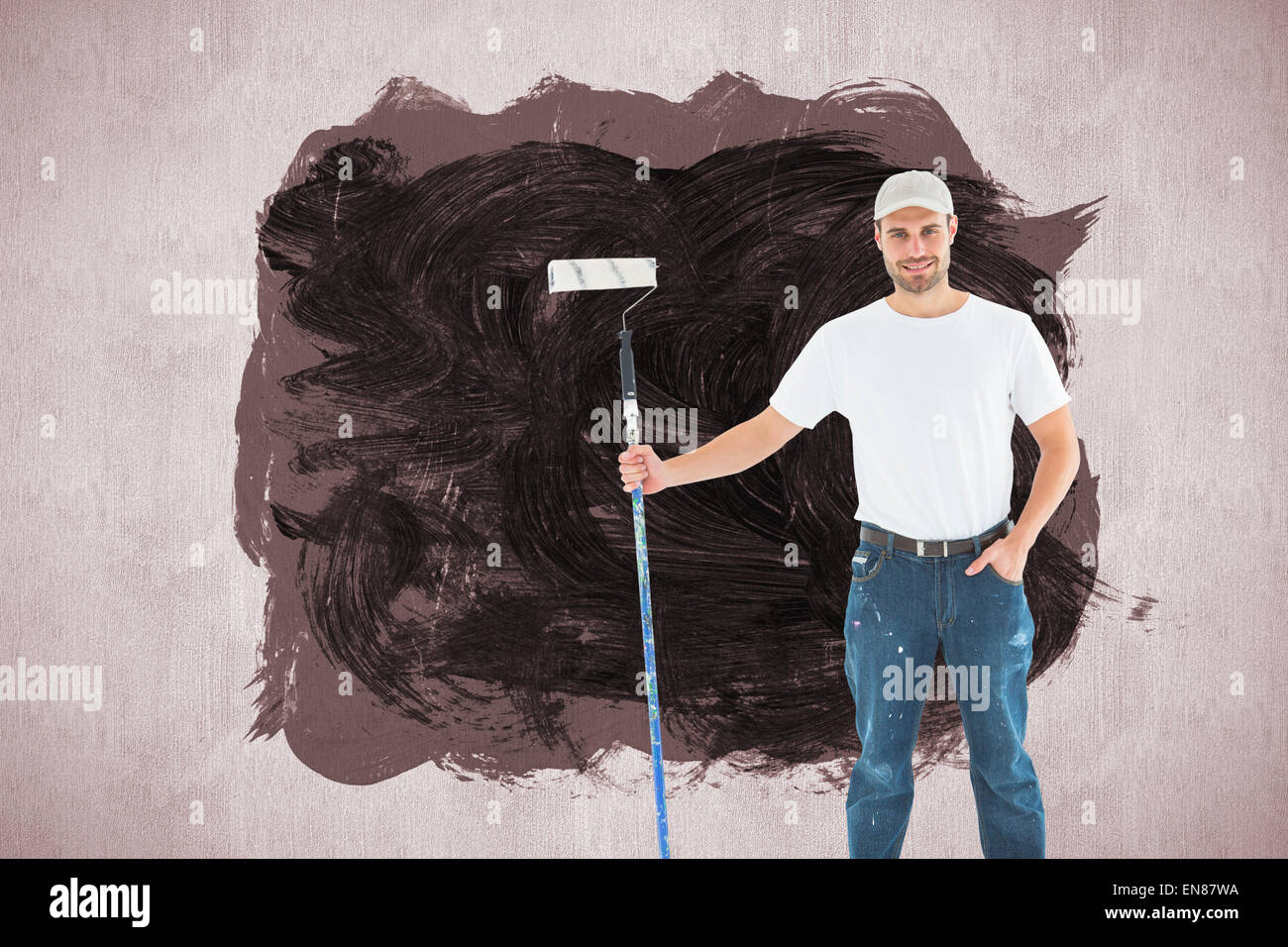 Image composite de l'homme confiant holding paint roller sur fond blanc Banque D'Images