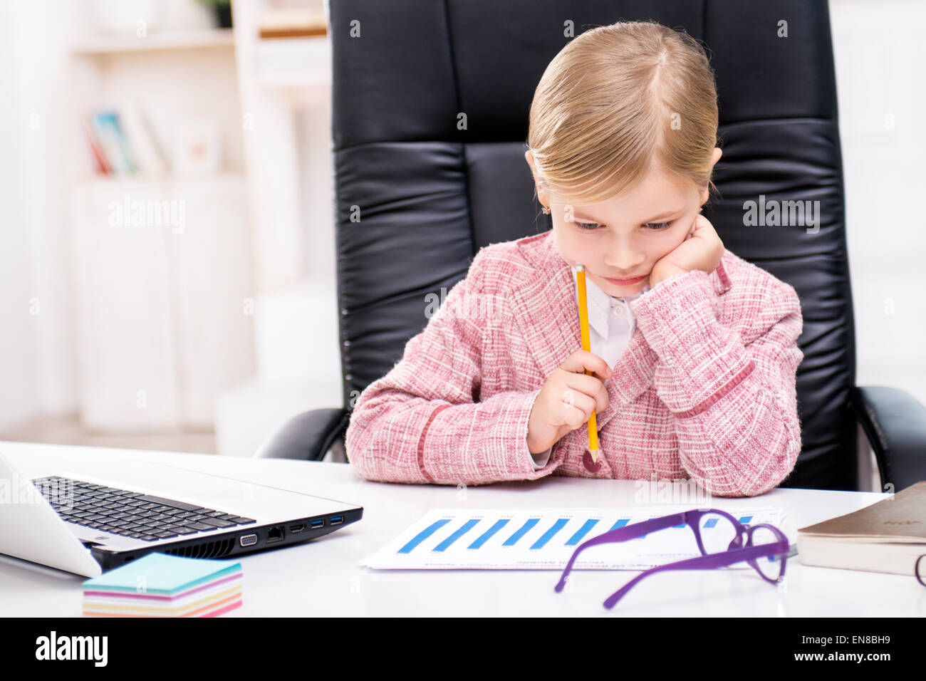 Peu cute girl jouer rôle de femme d'affaires Banque D'Images