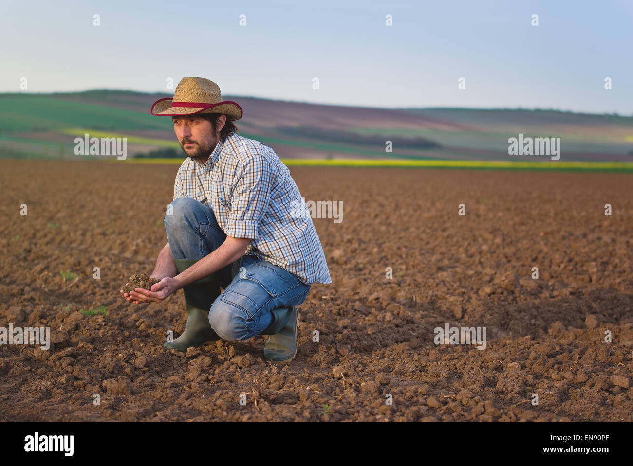 Agriculteur examine sur la qualité des sols agricoles fertiles terres agricoles, Agronome Contrôle de sol dans les mains Banque D'Images