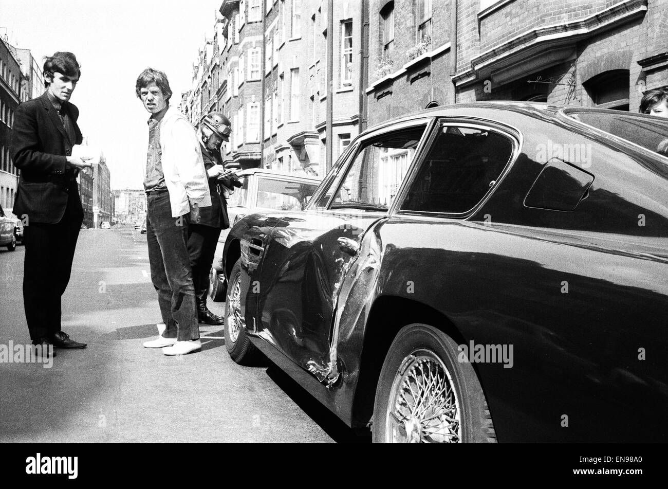 Rolling Stones : 28 août 1966, Mick Jagger est minuit blue Aston Martin DB6 a été impliqué dans une collision avec un véhicule en Kraft Foods Great Titchfield Street, London. L'Amie de Jagger Chrissie Shrimpton regarde Mick a ses particularités prises par un p Banque D'Images