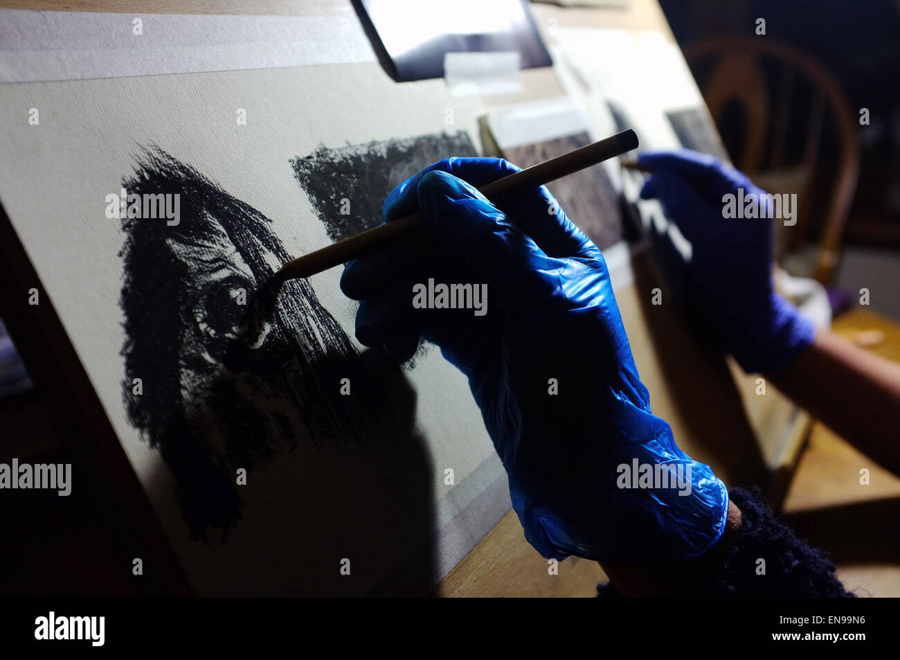 Les mains gantées de dessiner des chevaux à l'aide de crayons pastels. Banque D'Images
