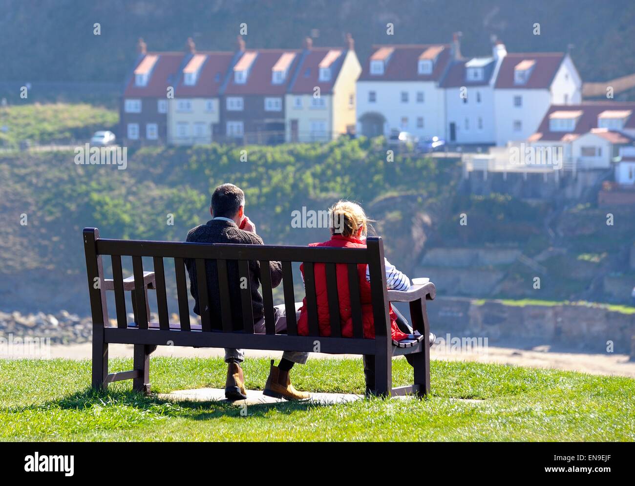 Un couple assis sur un banc, à Whitby, North Yorkshire Angleterre UK Banque D'Images