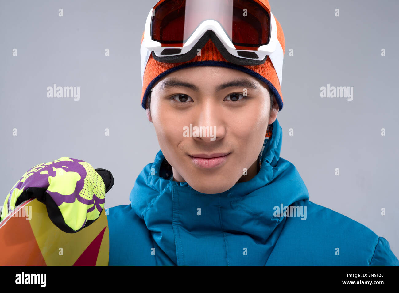 Portrait of a young man holding a snowboard looking at camera Banque D'Images