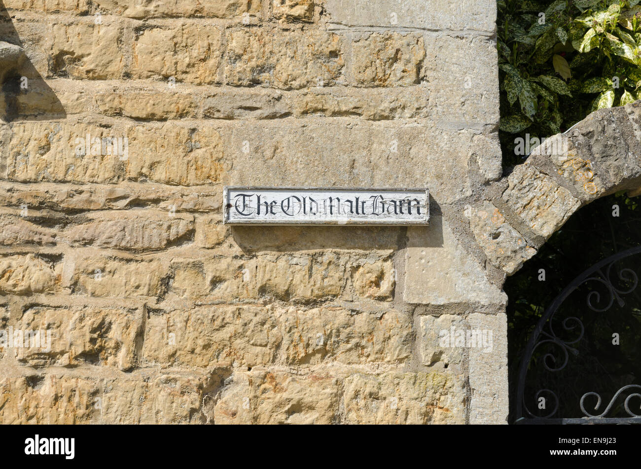 Inscrivez-vous pour l'ancienne grange de malt sur un mur en pierre de Cotswold, dans le village de Bourton On The Water Banque D'Images