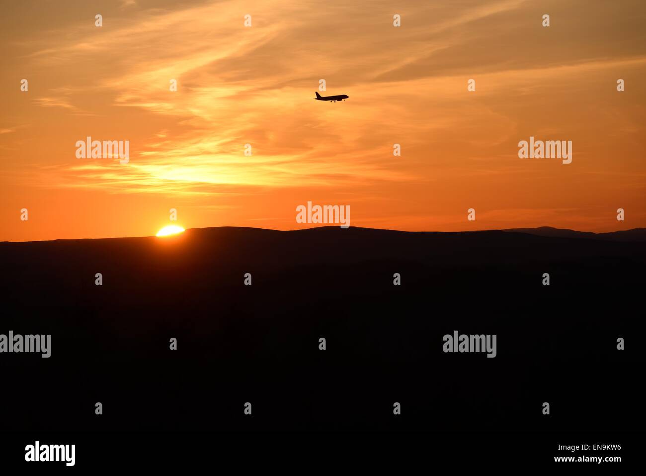 Jet s'approchant de l'aéroport international de Glasgow alors que le soleil se couche sur l'horizon en Ecosse, Royaume-Uni Banque D'Images