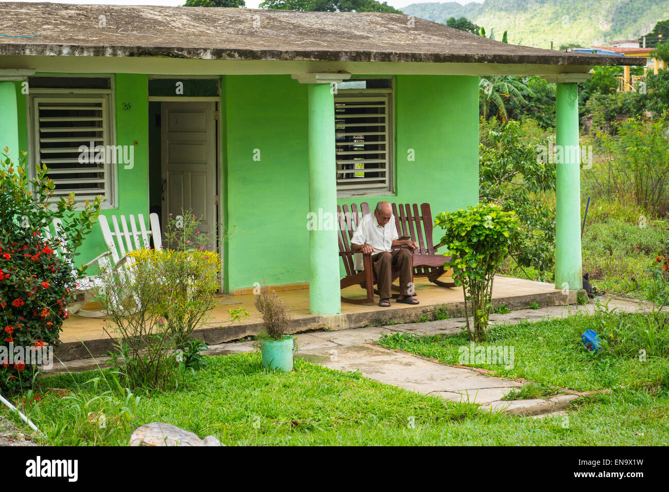 Vinales Cuba vieil homme sur une chaise berçante maison verte portique  veranda volets en bois colonial à arcades Photo Stock - Alamy