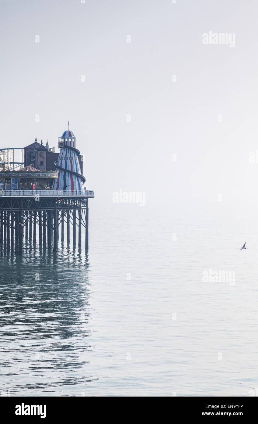 La jetée de Brighton avec ses Helter Skelter se reflétant dans la mer sur un jour brumeux, Brighton, Sussex, Angleterre. Banque D'Images