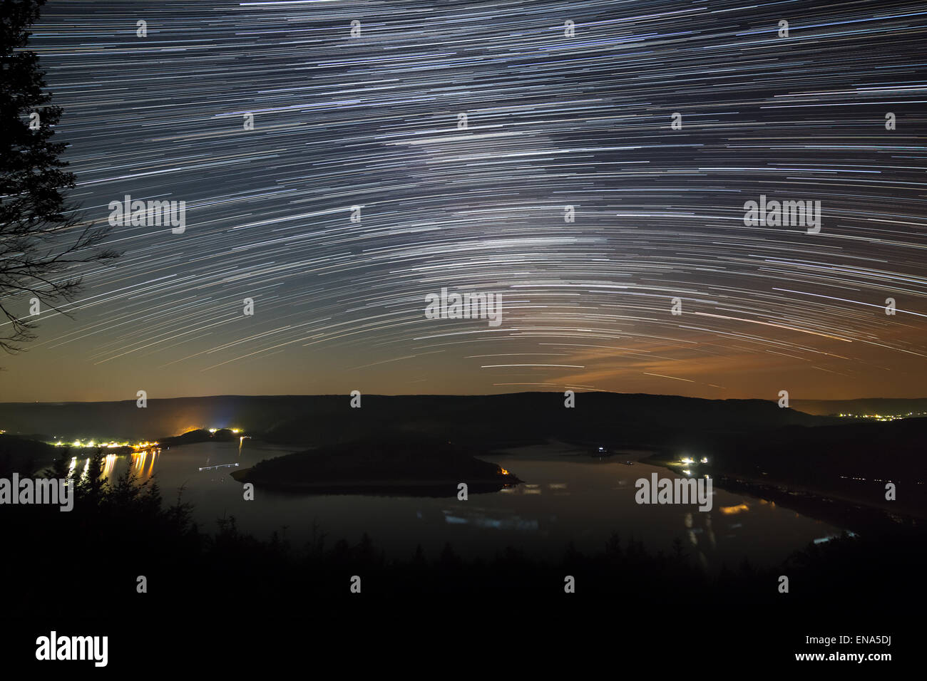 Star trails de la voie lactée au-dessus du lac Rursee en Allemagne dans une courte nuit d'été Banque D'Images