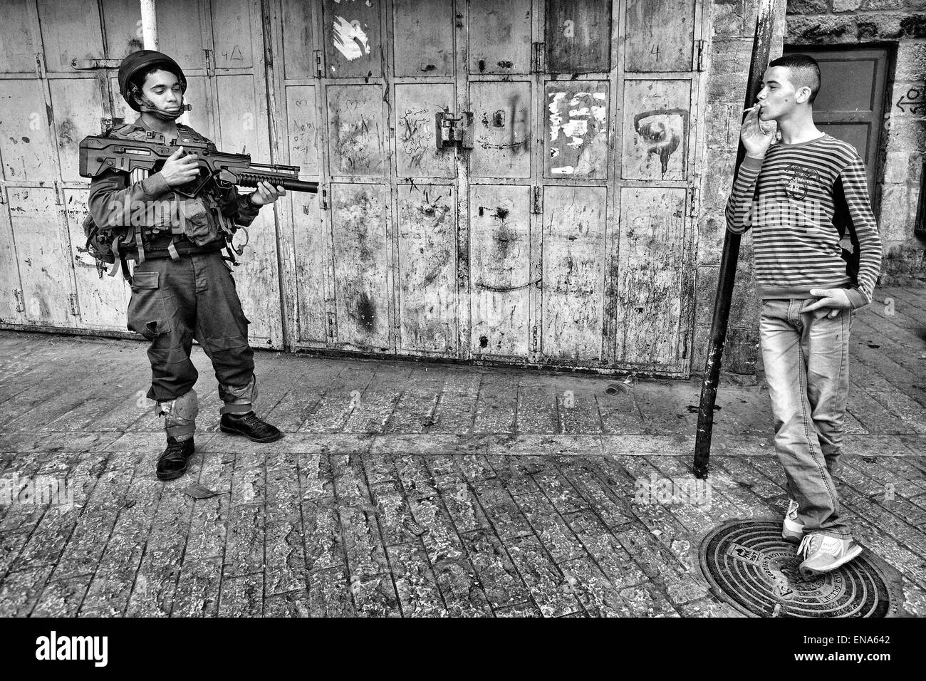 Hébron, en Palestine. Mar 19, 2011. Un garçon palestinien railleries un jeune, lourdement armés encore soldat israélien à Hébron. Mar. 19, 2011. Cisjordanie, Palestine. © Gabriel Romero/ZUMA/Alamy Fil Live News Banque D'Images