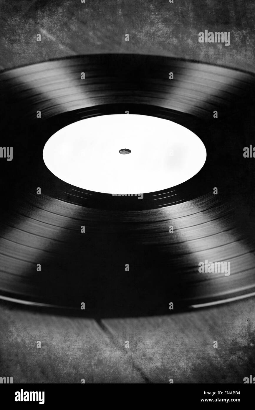 Version noir et blanc de disque vinyle avec étiquette blanche, sur un plancher en bois, planches, texturé, vintage retro Banque D'Images