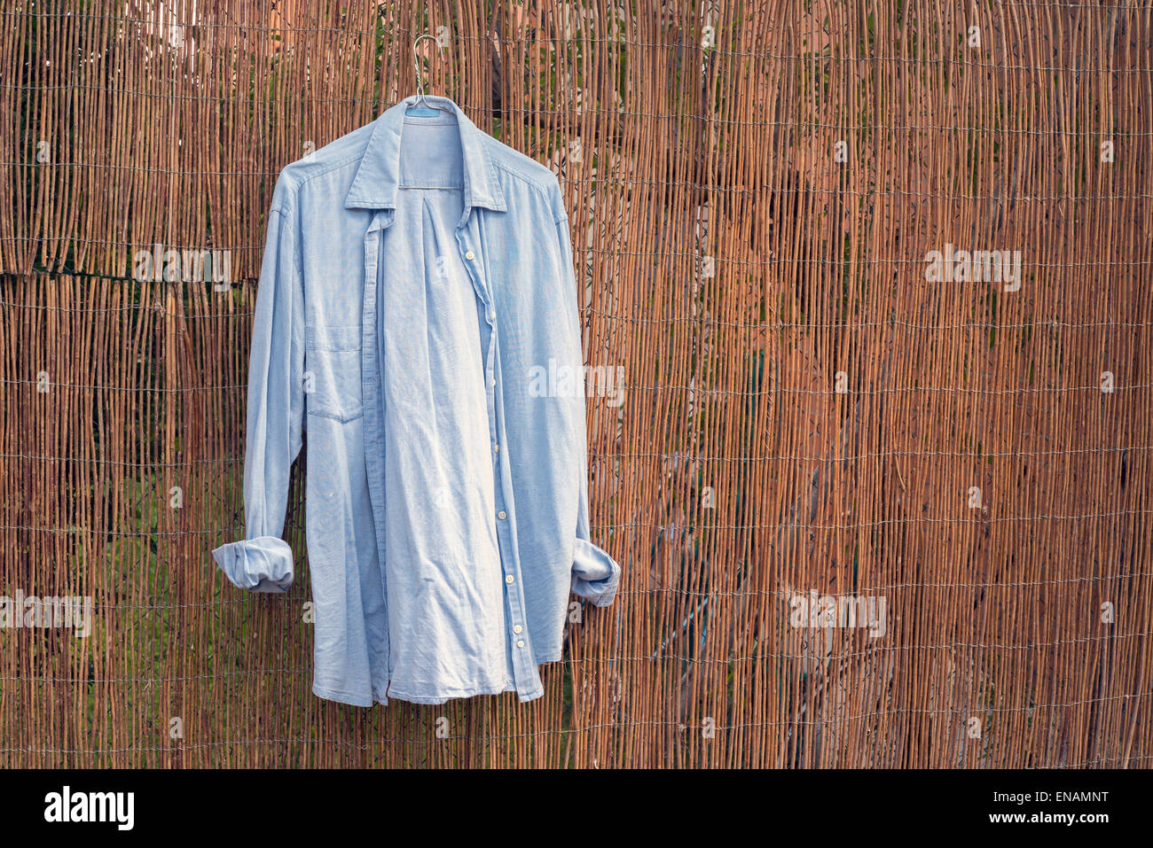 Chemise bleu accroché sur le mur en osier Banque D'Images