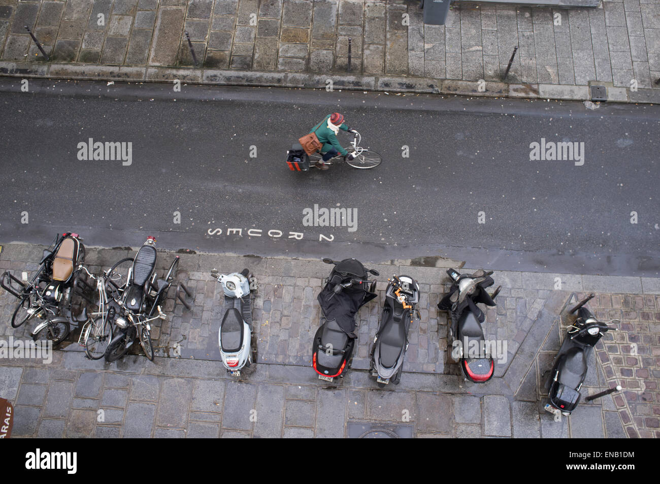 Un cycliste passe une rangée de Scooters et motocyclettes Banque D'Images