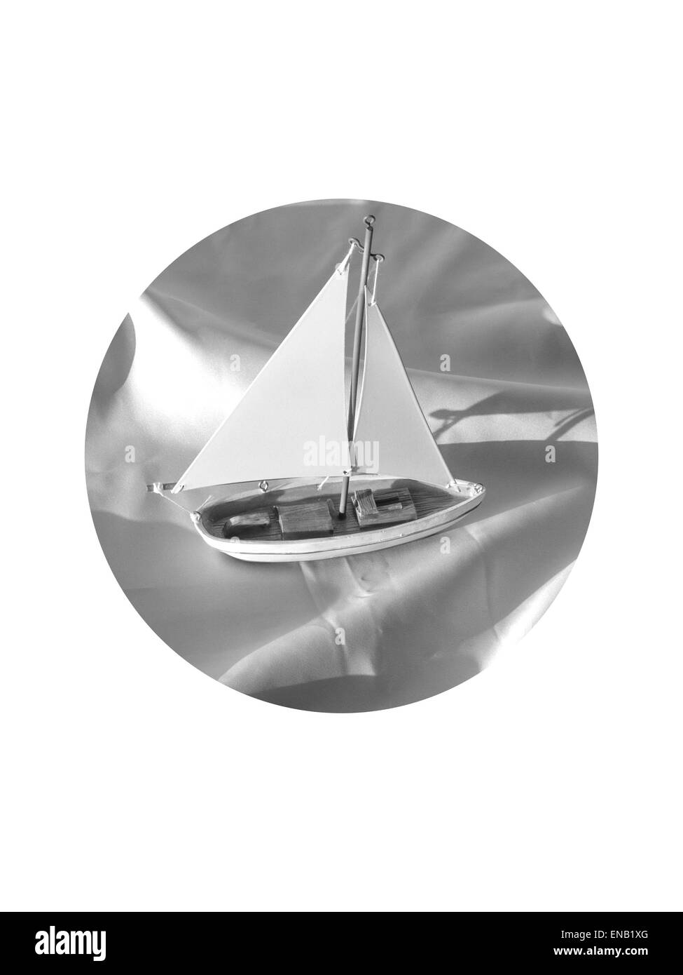 Jouet bateau navigue loin sur un drap de lit de courbes en noir et blanc - coupe circulaire sur fond blanc Banque D'Images