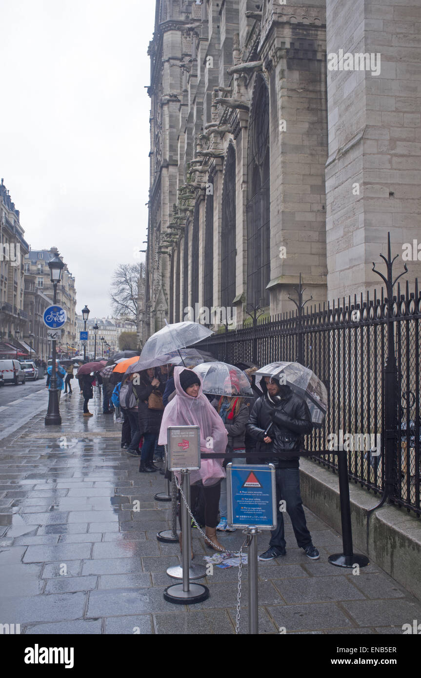 Les touristes d'attente de la pluie pour voir la cathédrale Notre Dame de Paris Banque D'Images