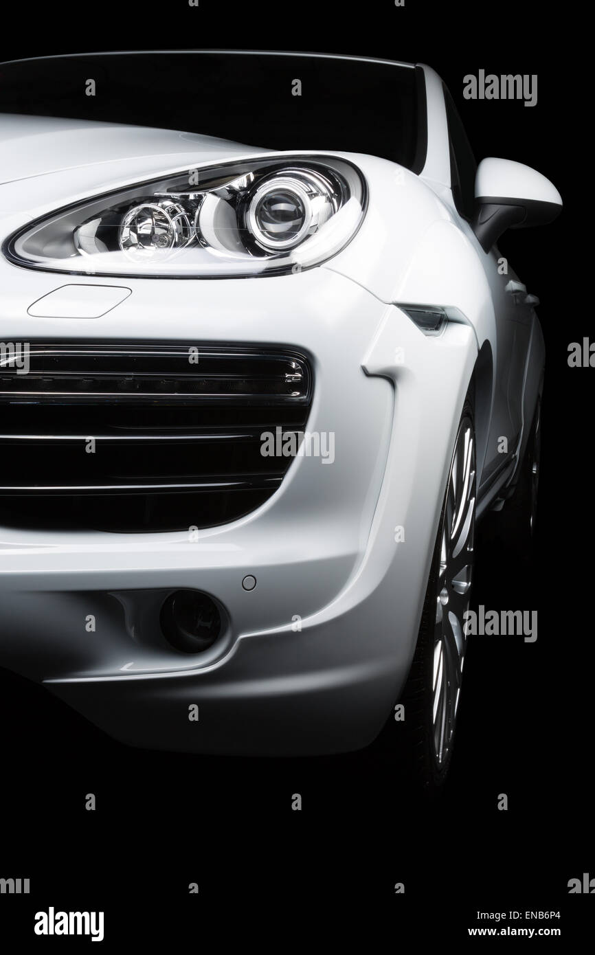 Porsche Cayenne avec Kahn bodykit Design en blanc, avant detail de projecteurs, d'une grille et d'arcs. Sur un fond noir. Banque D'Images