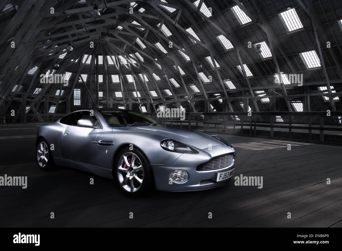 Aston Martin Vanquish dans un ancien bâtiment industriel avec windows et des ruisseaux de lumière dans votre véhicule. Banque D'Images
