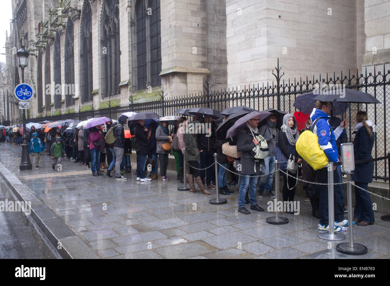 Les touristes d'attente de la pluie pour voir la cathédrale Notre Dame de Paris Banque D'Images