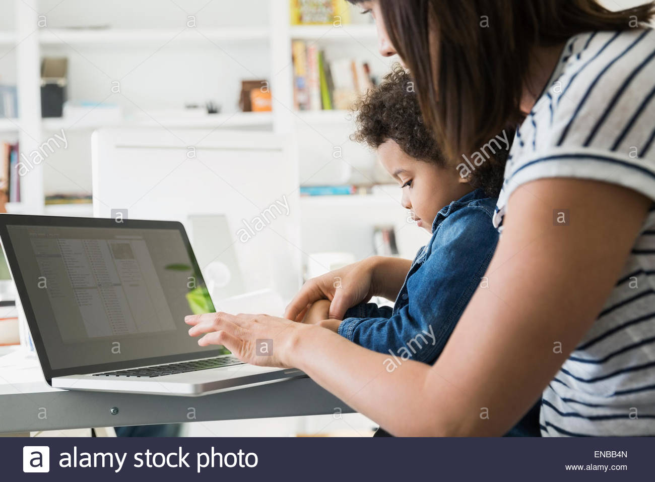 Mère et fille typing on laptop Banque D'Images