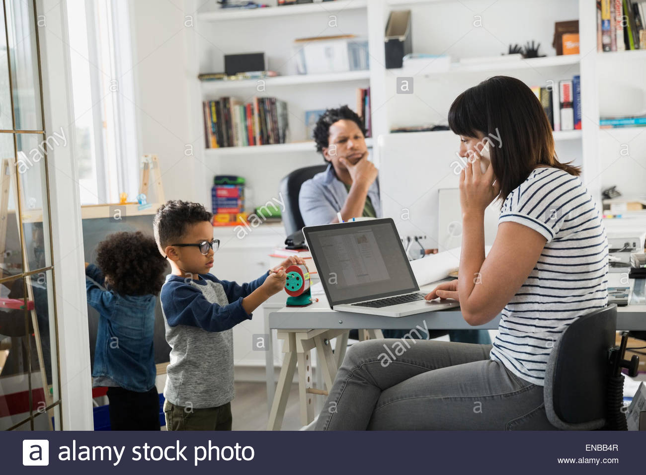 Travail à domicile les parents avec enfants jouant Banque D'Images