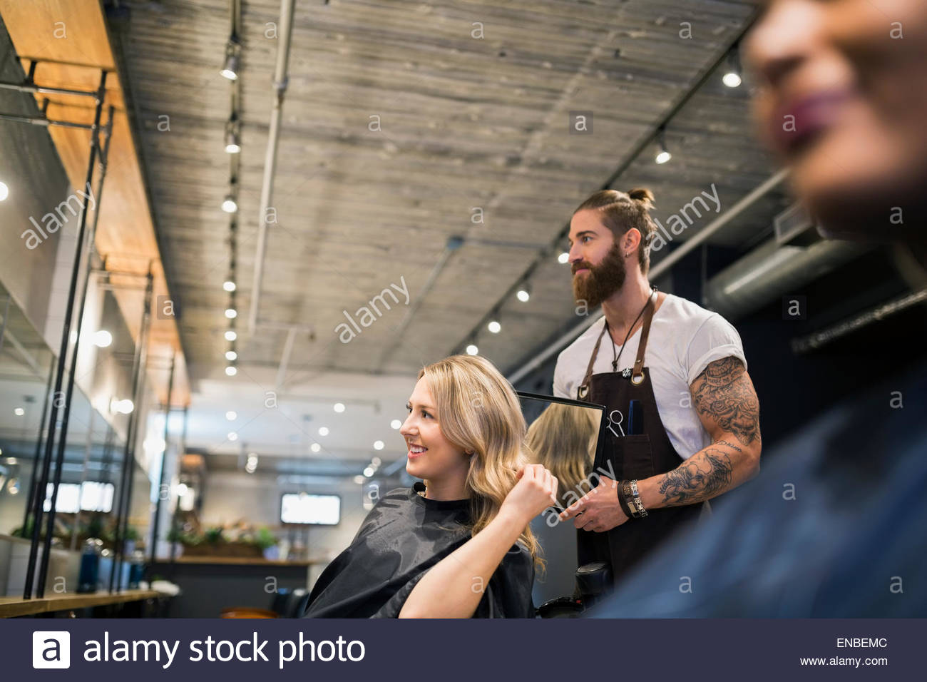 Hairstylist showing woman hair avec miroir de coiffure Banque D'Images