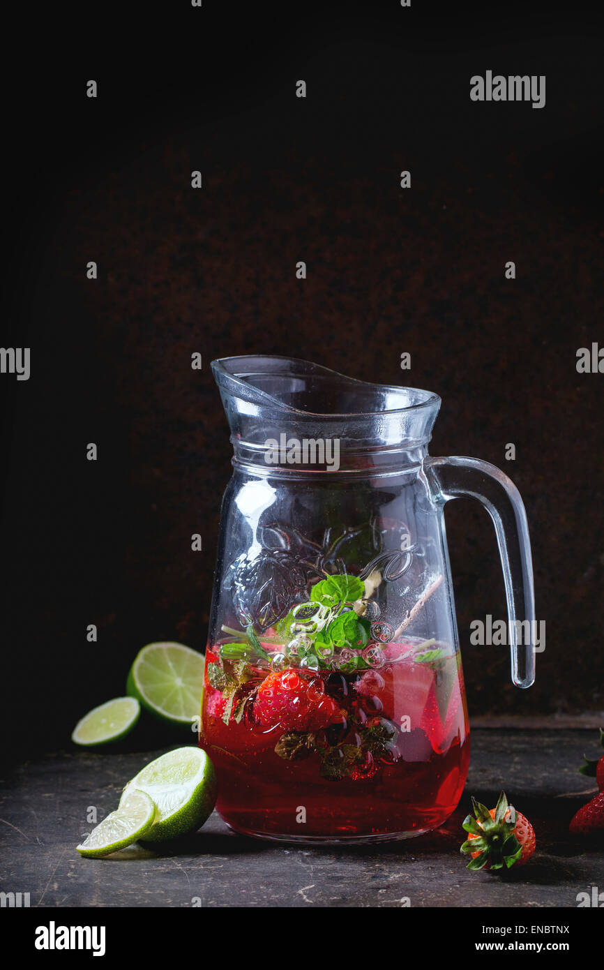 Verseuse en verre de limonade aux fraises, servi avec des fraises fraîches, Menthe et citron vert sur fond sombre. Voir la série Banque D'Images
