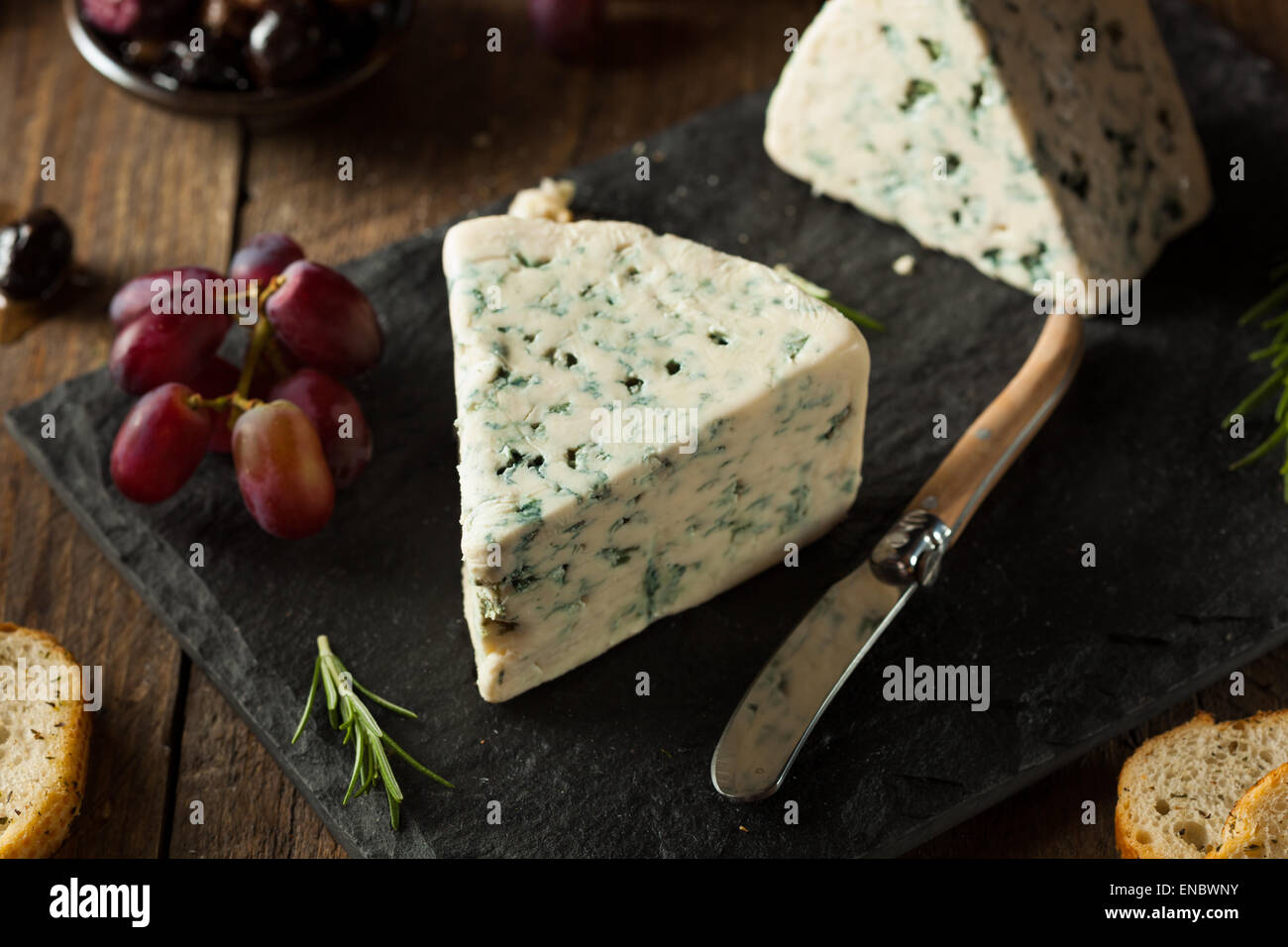 Fromage bleu organique caler avec des olives et raisins Banque D'Images