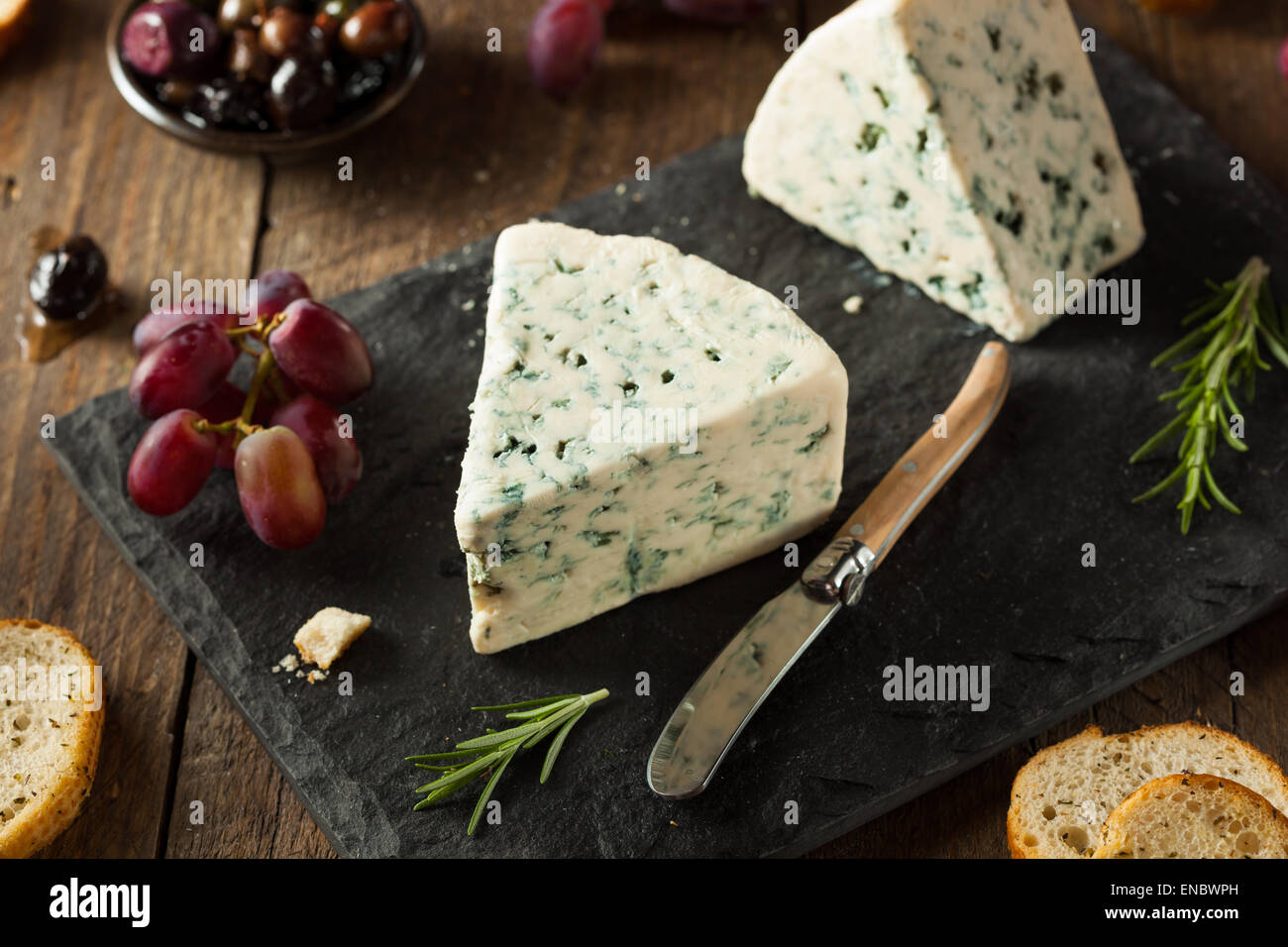 Fromage bleu organique caler avec des olives et raisins Banque D'Images