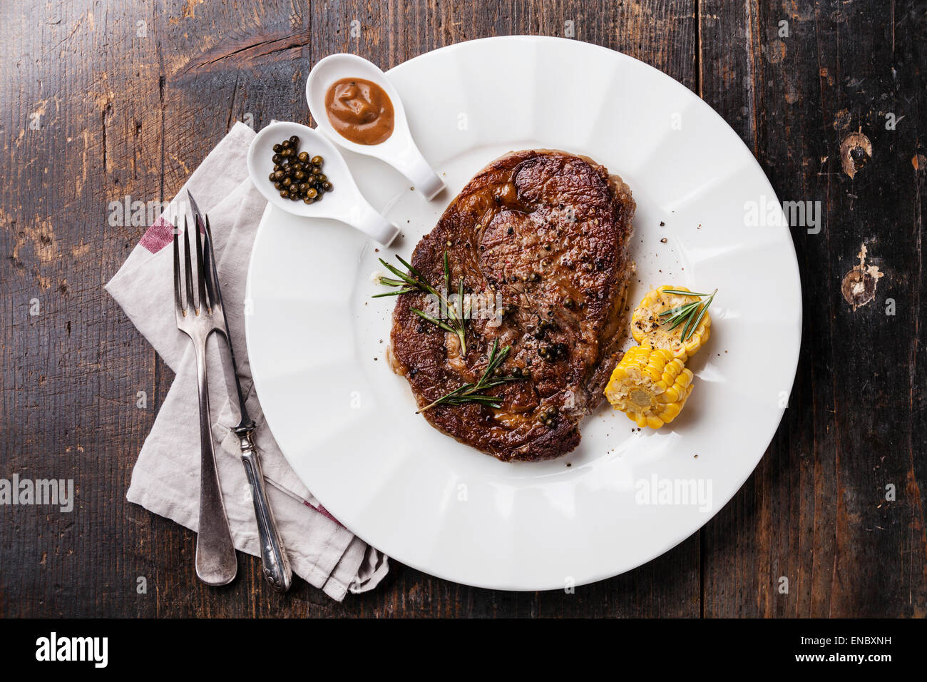 Black Angus Steak grillé sauce au poivre et faux-sur plaque blanche sur fond de bois Banque D'Images