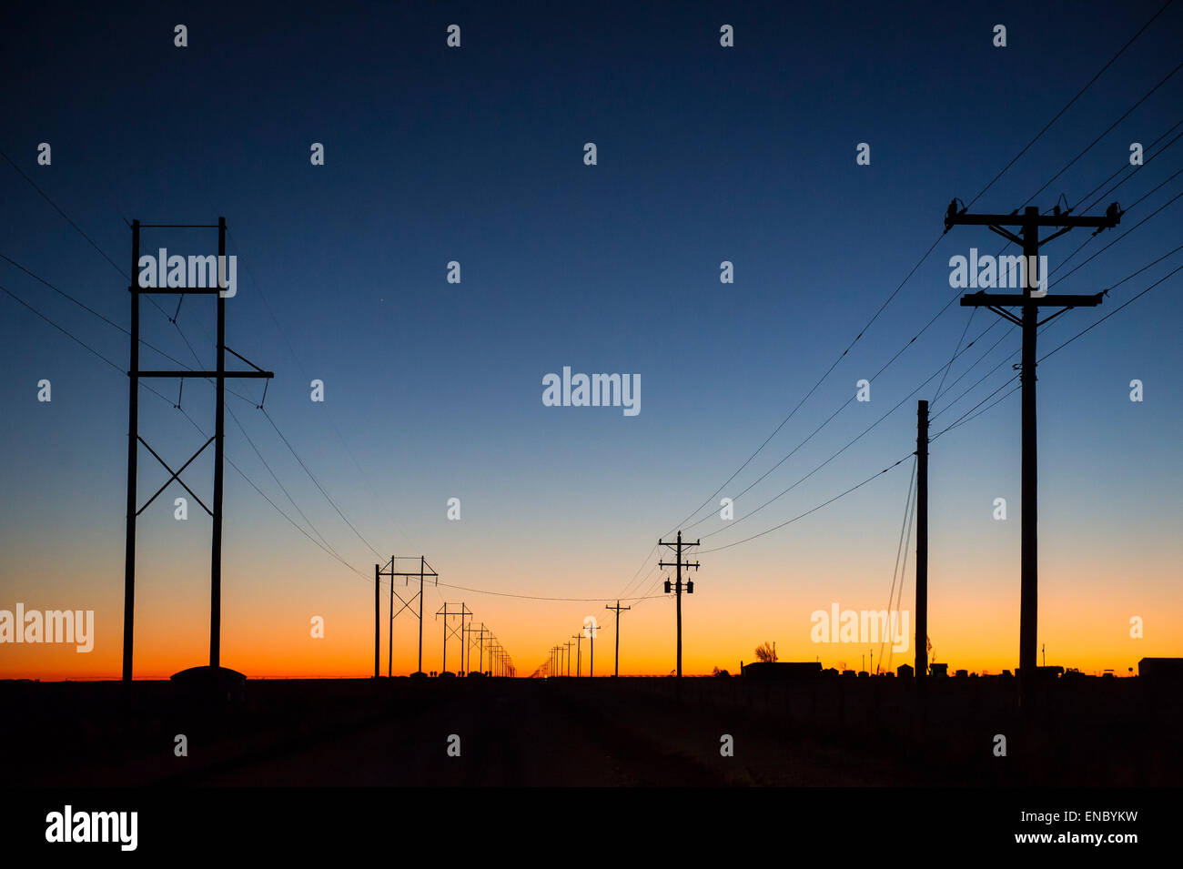 Le soleil se couche derrière les lignes d'électricité dans l'Oklahoma panhandle. Banque D'Images