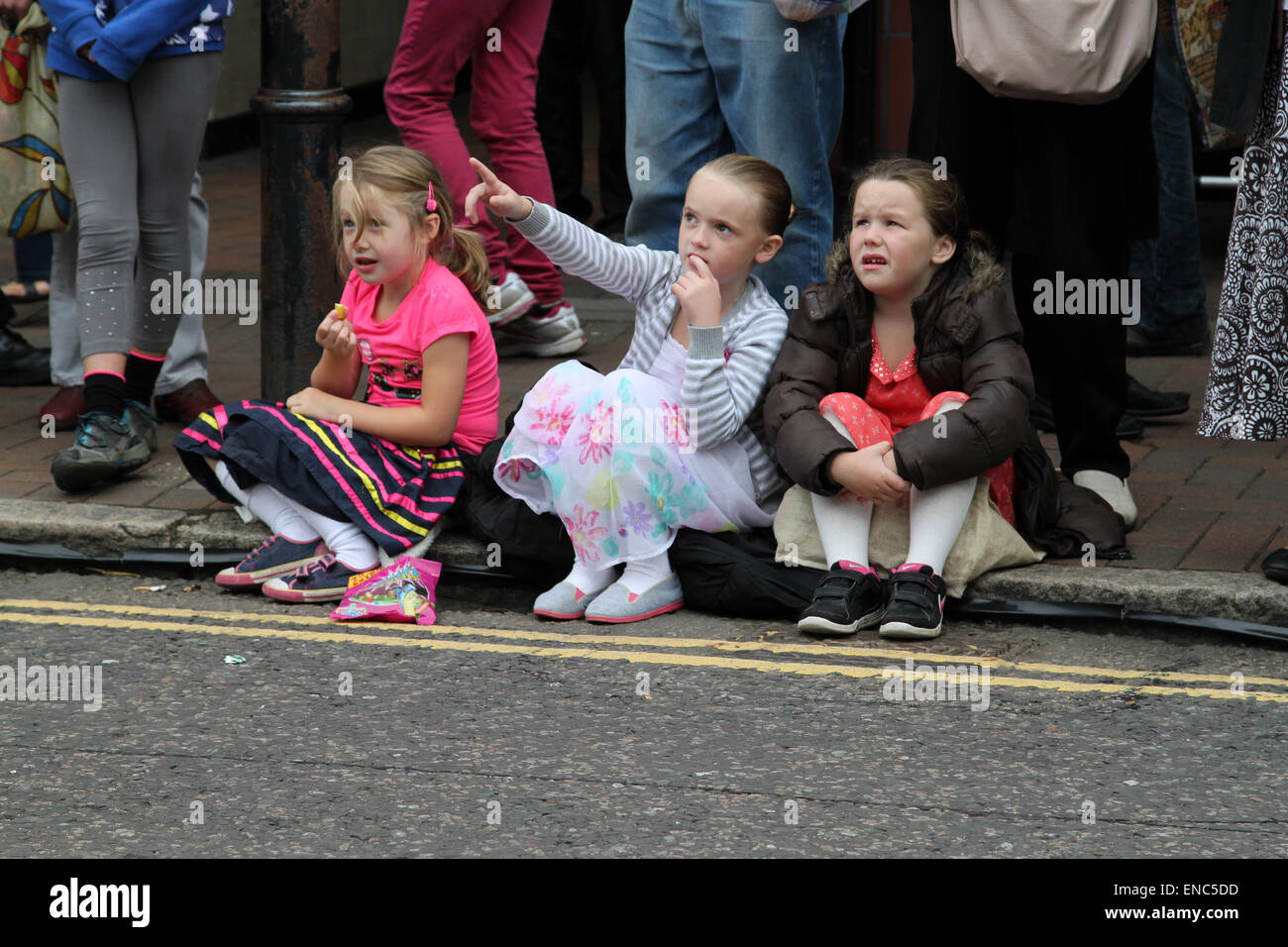 Des enfants assis sur la chaussée à la Festival International de Marionnettes en Witham, Essex Banque D'Images