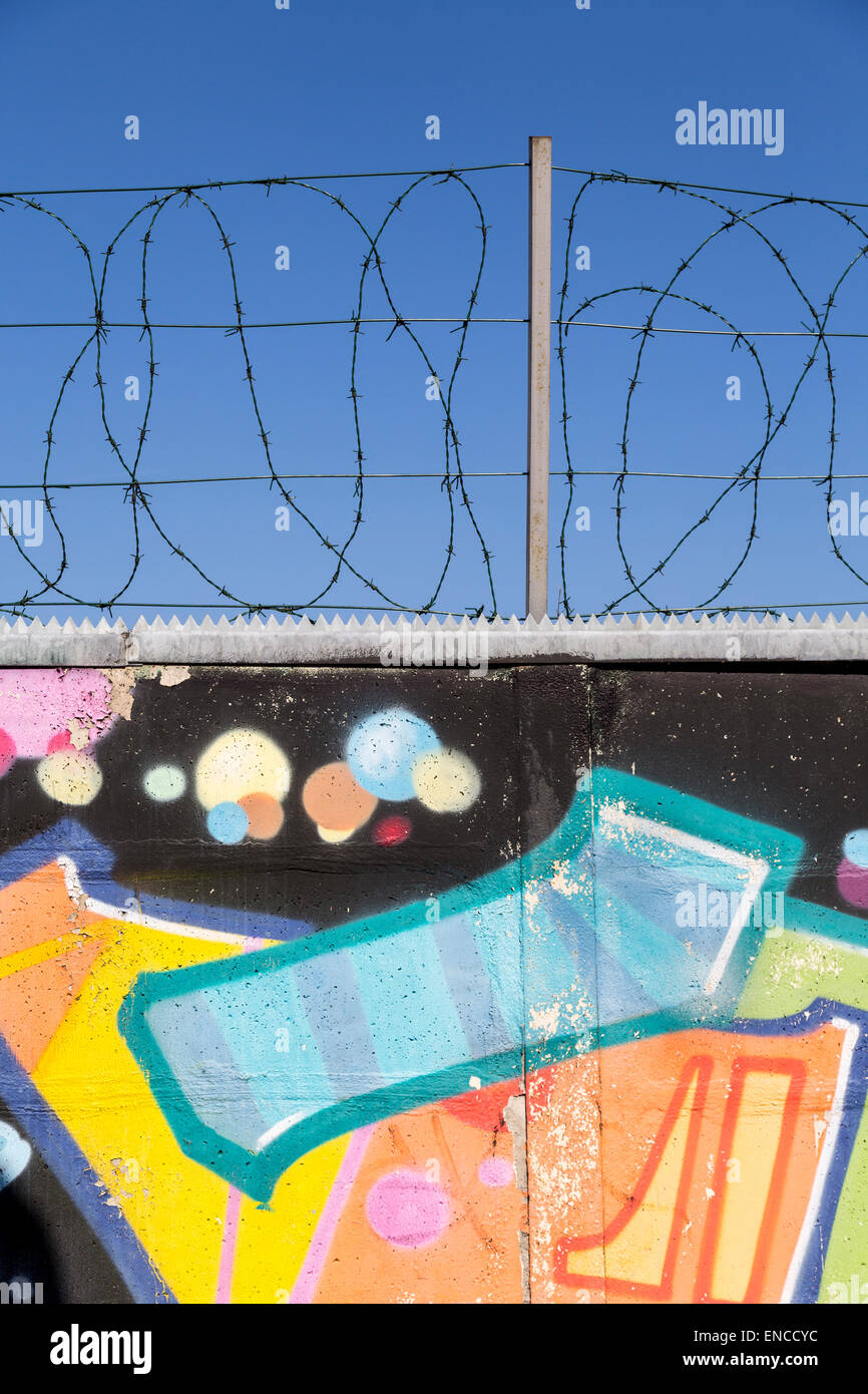 Mur de graffiti avec Barb Wire sur le dessus Banque D'Images