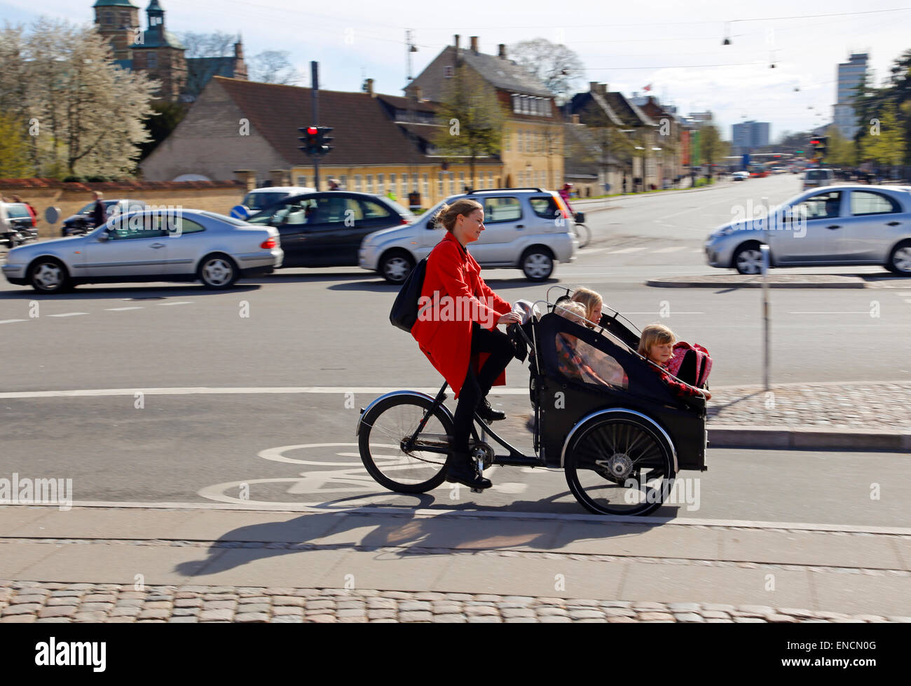 Une mère à vélo avec ses trois enfants dans un support à l'avant à Copenhague, Danemark Banque D'Images