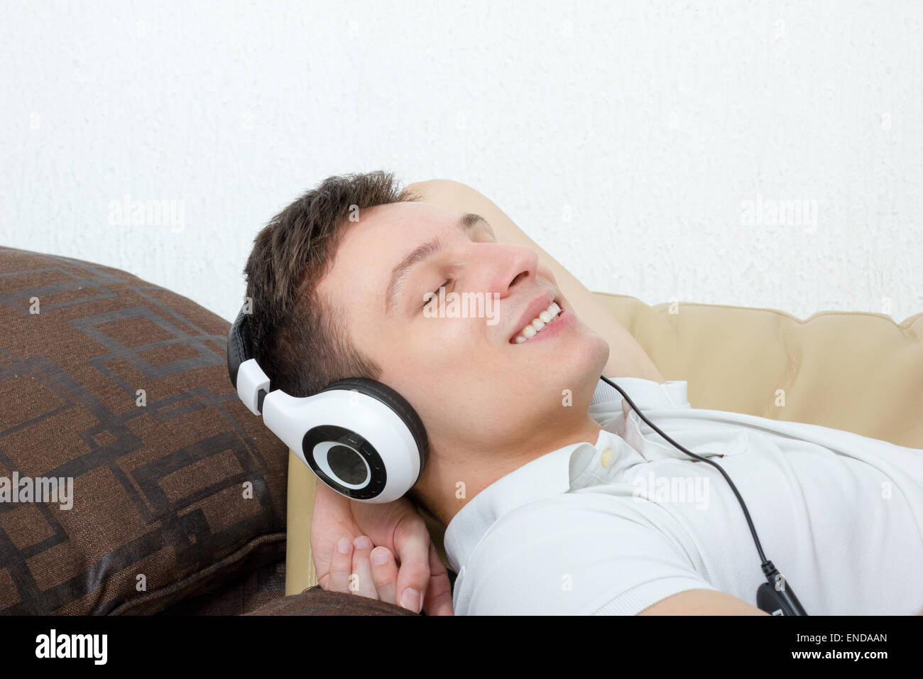 Beau jeune garçon dans un casque d'écoute de la musique avec magnétophone  isolé sur fond vert Photo Stock - Alamy